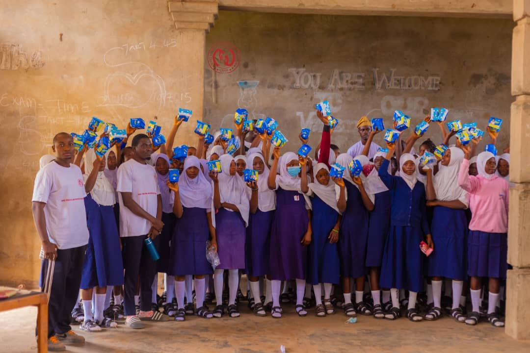 Pupils holding up OYIF branded notebooks